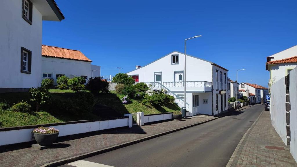 an empty street with white buildings on the side at Apartamento do Marquês in Santa Cruz das Flores