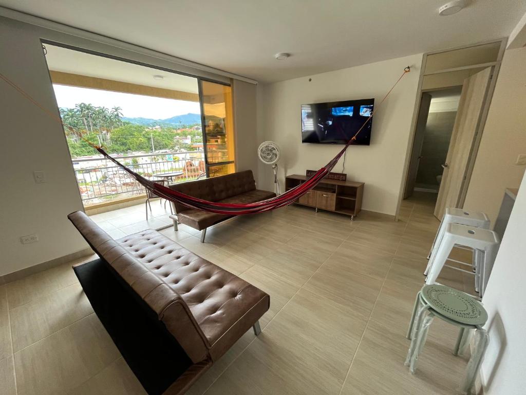 ein Wohnzimmer mit einem Sofa und einer Hängematte in der Unterkunft Apartamento con piscina y parqueadero a 7 min del centro in Villeta