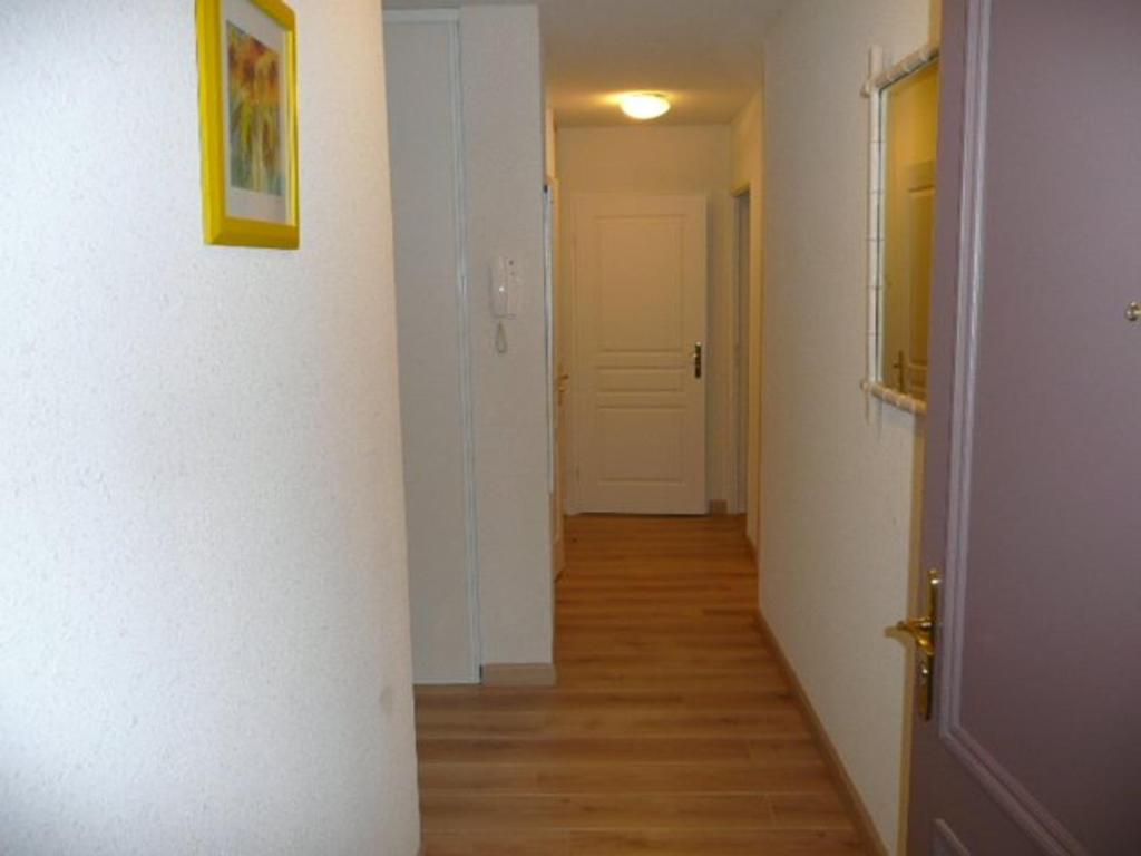 korytarz z białymi ścianami, drewnianymi podłogami i drzwiami w obiekcie Bel appartement plage, 2 chambres, balcon ensoleillé, garage privatif, animaux acceptés, WIFI optionnel - FR-1-674-2 w mieście Berck-sur-Mer