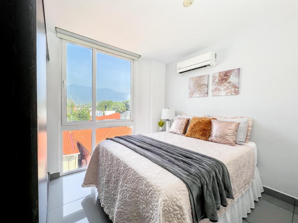 圣佩德罗苏拉Lujoso y acogedor condominio ejecutivo/familiar的一间带床和窗户的白色卧室