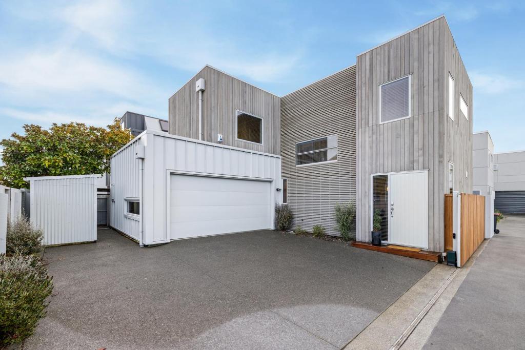 una casa moderna con un garage bianco di City Escape - Christchurch Central Apartment a Christchurch