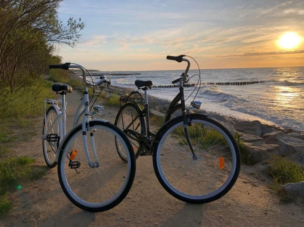twee fietsen geparkeerd op het strand bij zonsondergang bij Seaside Czarna Mewa in Kołobrzeg