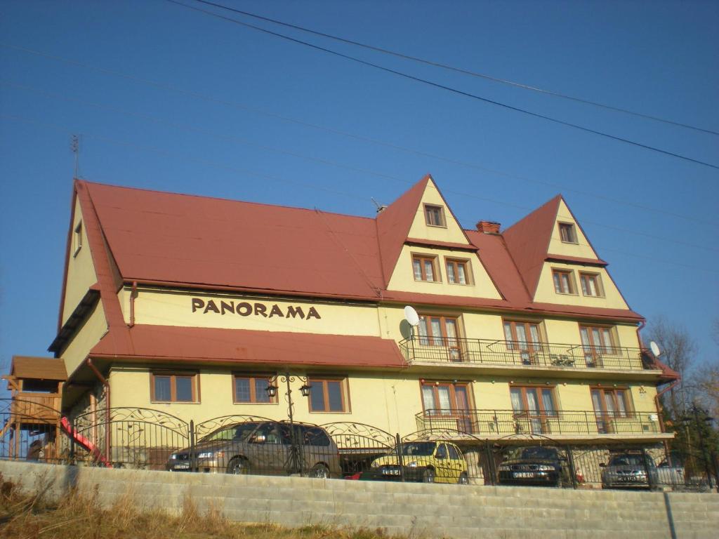 a large building with cars parked in front of it at Ośrodek Wczasowy Panorama in Bukowina Tatrzańska