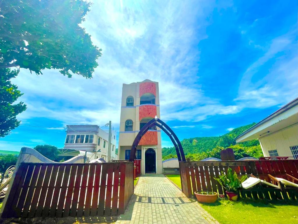 a building with a gate and a clock tower at Encounter Dream House in Green Island