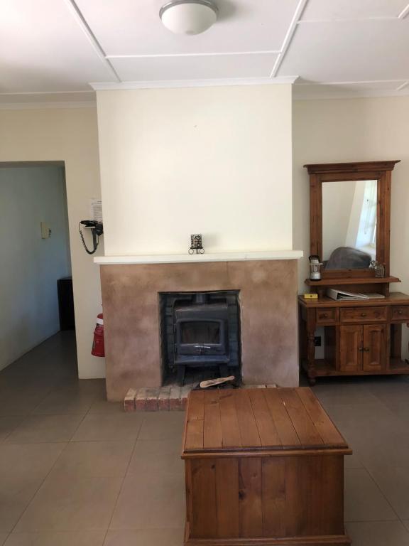 a living room with a fireplace and a coffee table at Nudlamutana Hut - Vulkathunha-Gammon Ranges National Park in Arkaroola