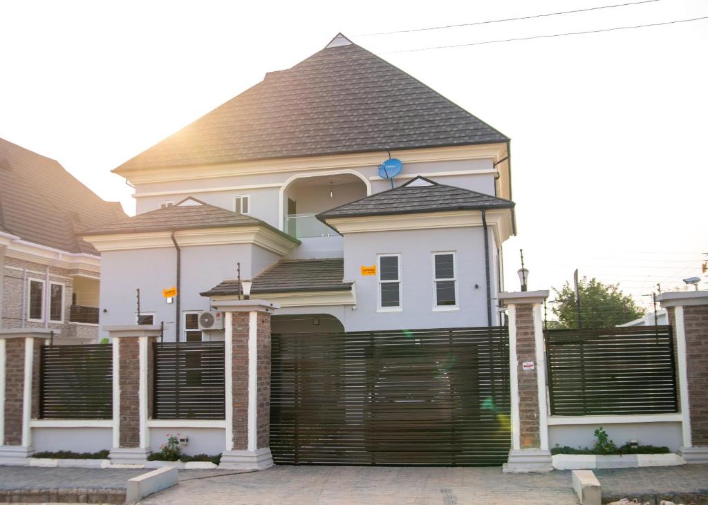 a white house with a large wooden garage door at Prince's - Villa - Minimum of 3 nights booking in Akure