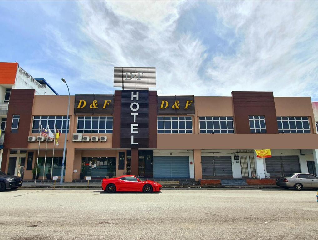a red car parked in front of a building at D&F BOUTIQUE HOTEL SENAWANG in Senawang