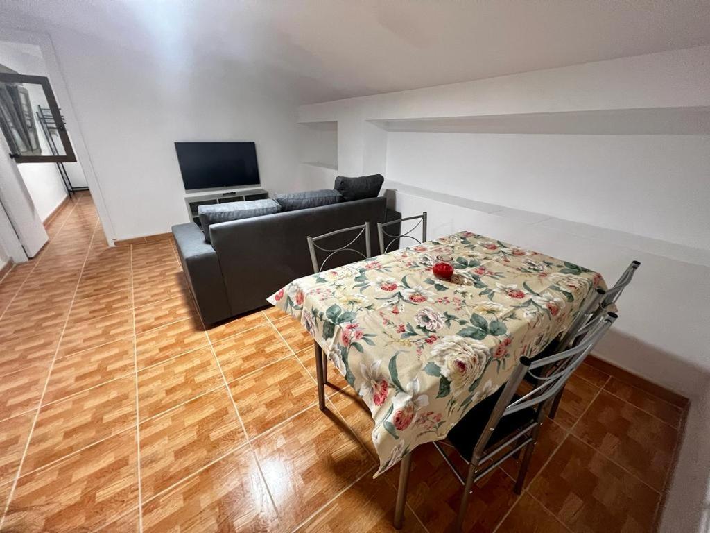 Atico CabezoDoce في كالاهورا: غرفة معيشة مع طاولة وأريكة