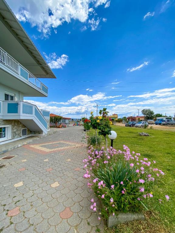 a walkway in front of a building with flowers at Seaview Aparthotel in Nea Potidaea