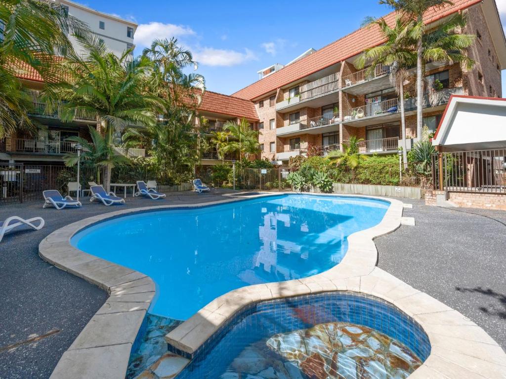 una piscina frente a un edificio de apartamentos en Hawaiian Gardens Unit 22 en Coffs Harbour