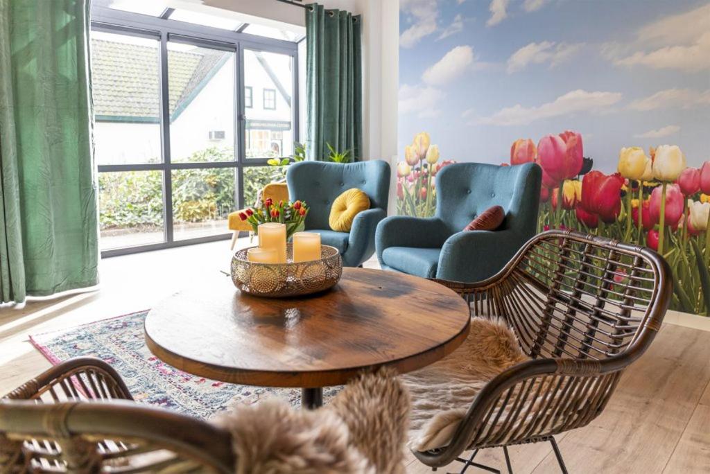 a living room with a table and chairs and tulips at Bed & Breakfast Bakker Meijer in Heemskerk