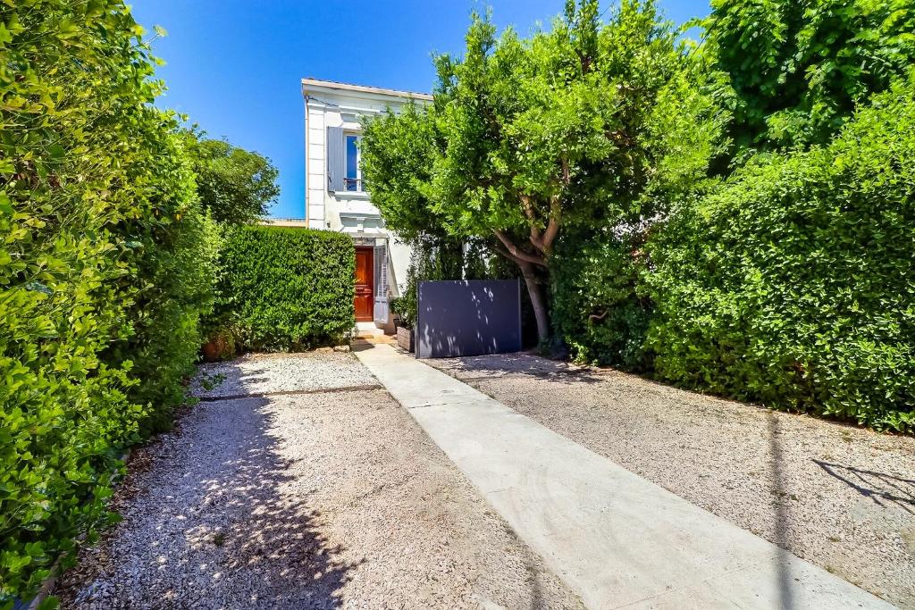 einen Fußweg vor einem Haus mit einem Baum in der Unterkunft La Maison in Istres