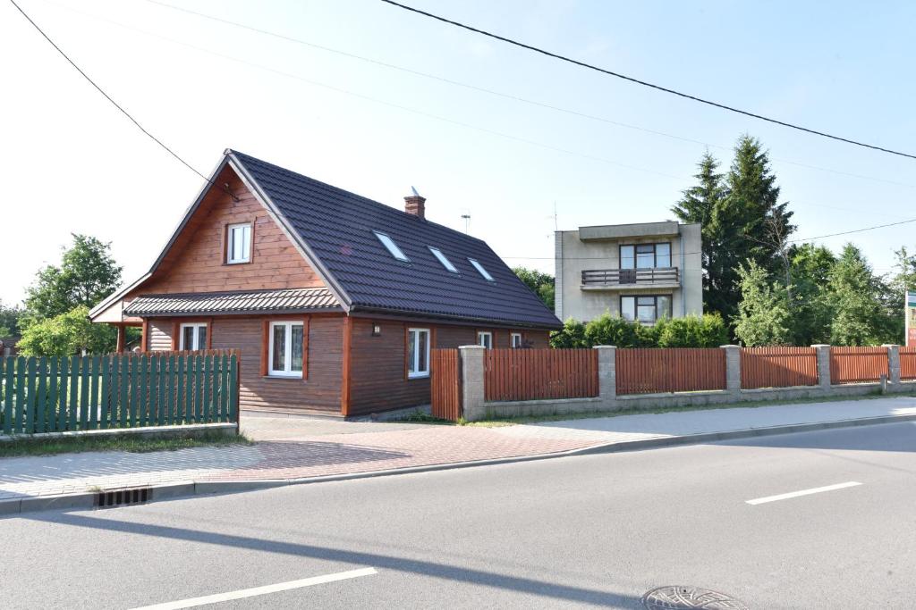 brązowy dom z czarnym dachem na ulicy w obiekcie Stokrotka w Białowieży