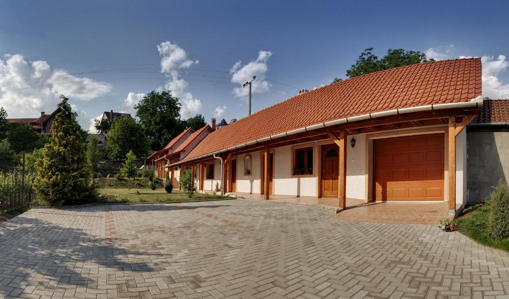 a house with a brick driveway in front of it at Nyitott Kapu Vendégház in Felsőtárkány