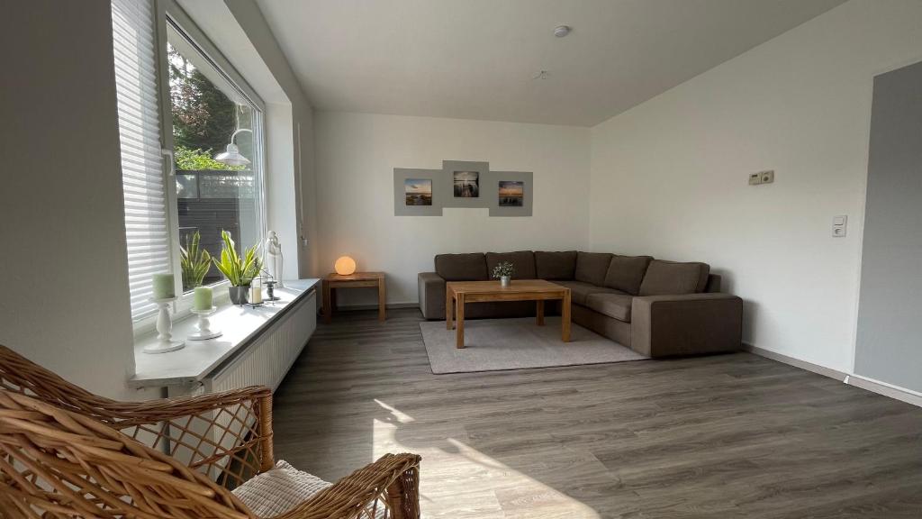 ein Wohnzimmer mit einem Sofa und einem Tisch in der Unterkunft Fischers Nordseehaus Bungalow mit Garten in Wilhelmshaven