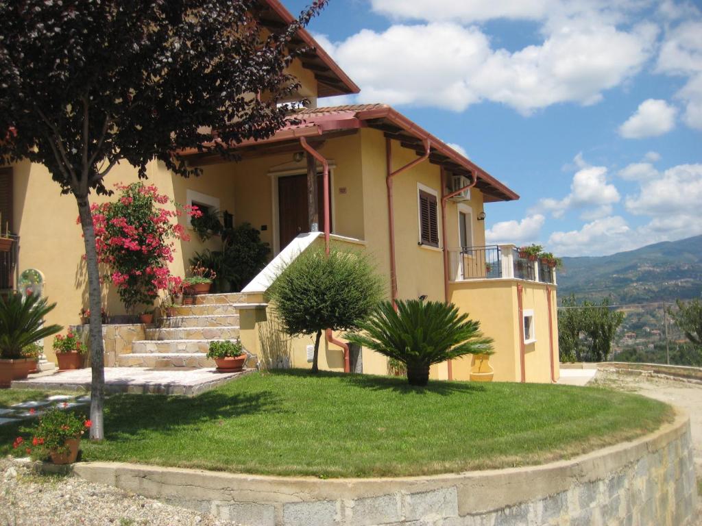 una casa con escaleras y plantas delante de ella en La Quercia, en Cosenza