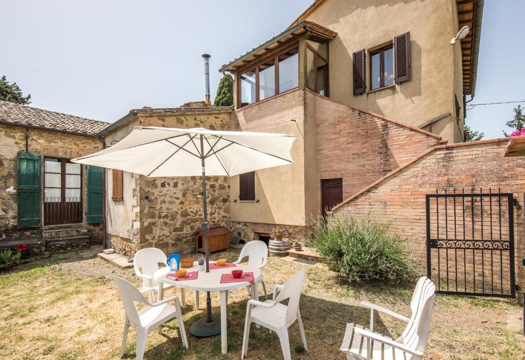 a table and chairs with an umbrella in a yard at Casa Vacanze del Borgo in Montalcino