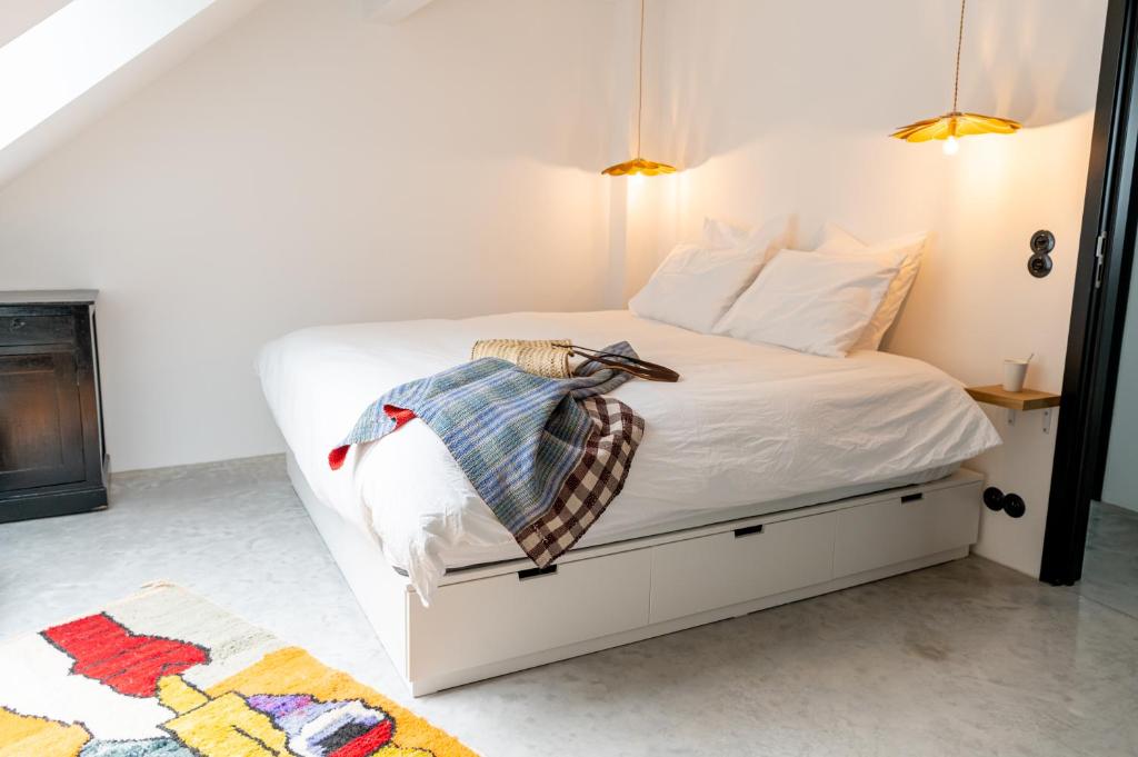 ein Schlafzimmer mit einem weißen Bett mit einer Decke darauf in der Unterkunft Espace 43 - Les 7 chambres in Namur