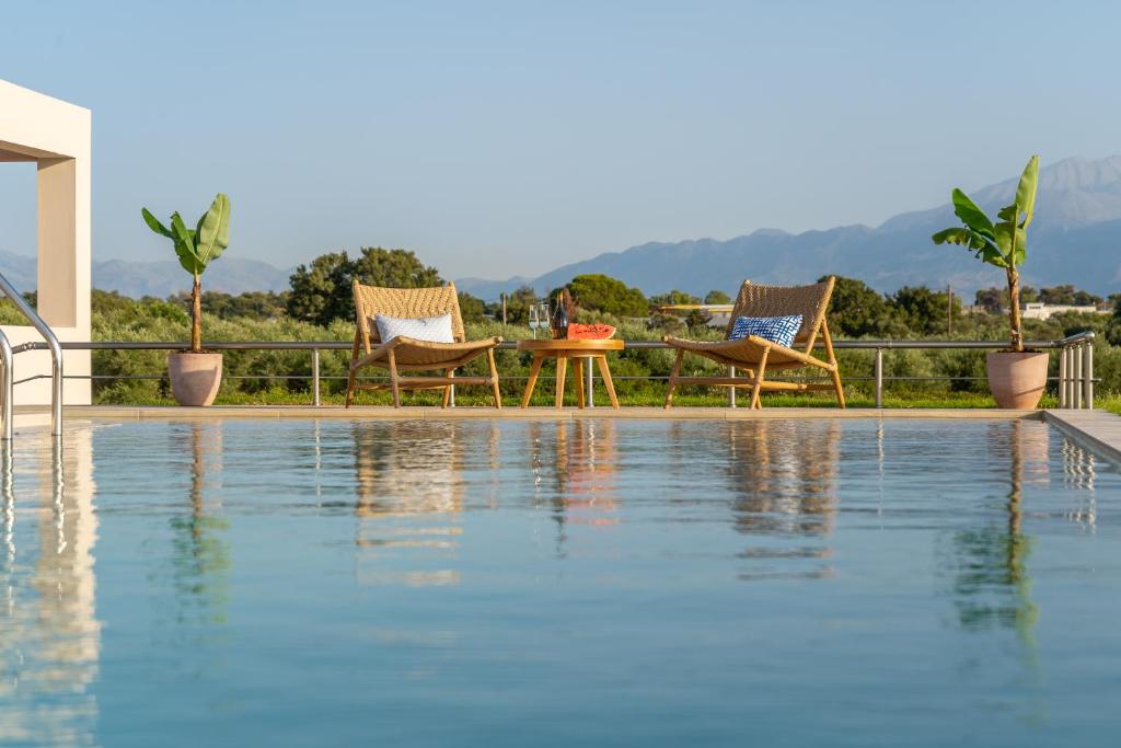 basen z dwoma krzesłami i stołem obok niego w obiekcie Villa Anastasia - Luxury Living w Chanii