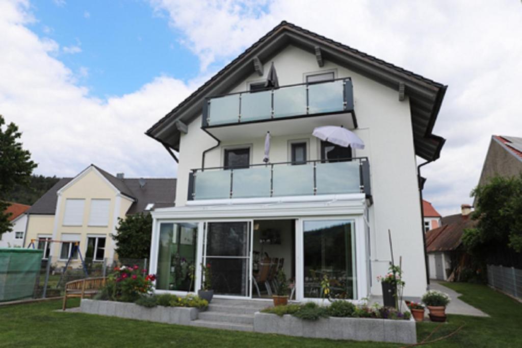 Casa blanca con ventanas grandes de cristal en Pension Agathe en Beilngries