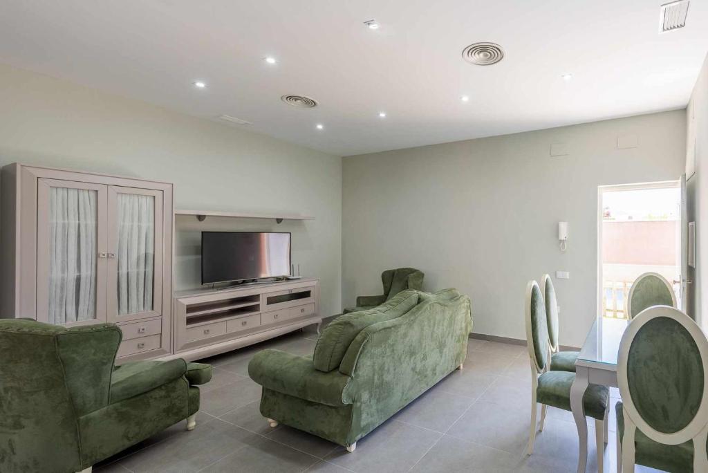 salon z 2 krzesłami i telewizorem w obiekcie Apartamento Torero II w mieście Marchena