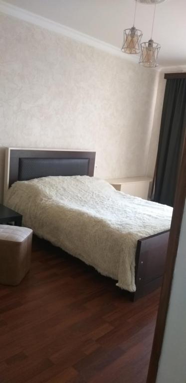 1 dormitorio con 1 cama con manta blanca en Apartment in Poti, en Poti