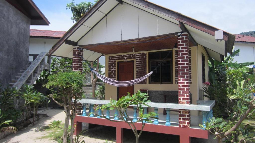 una pequeña casa con una hamaca delante en Charung Bungalows en Haad Rin