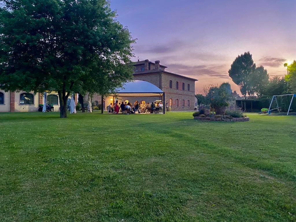 a group of people sitting in a gazebo in a yard at Agriturismo La Colmata in Cesa