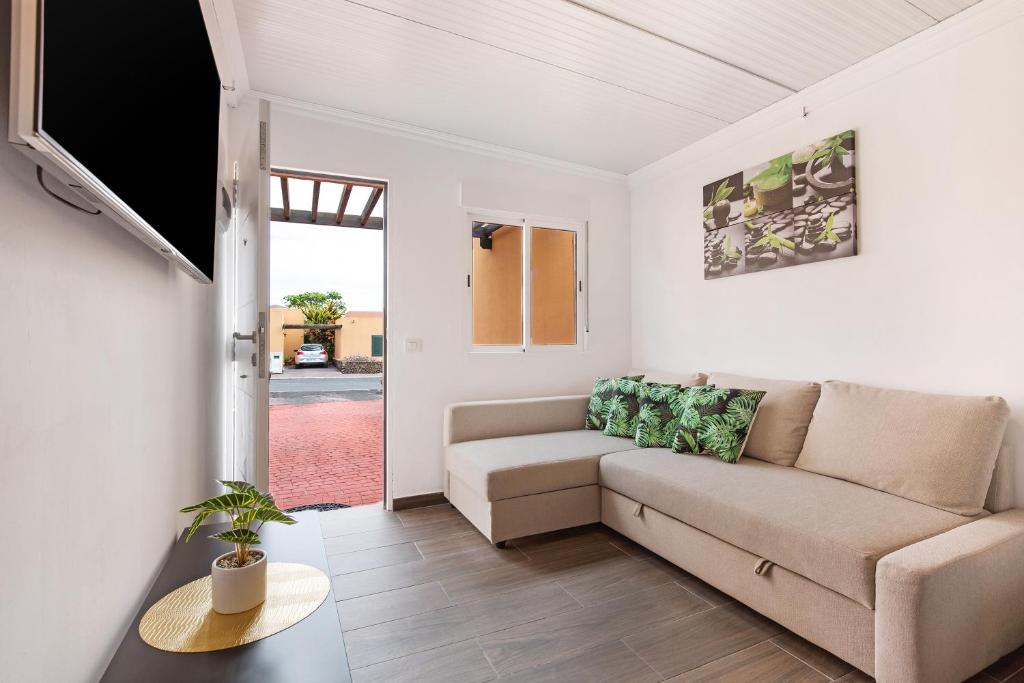 una sala de estar con un sofá y una mesa en Apartamento Dayely, en Corralejo