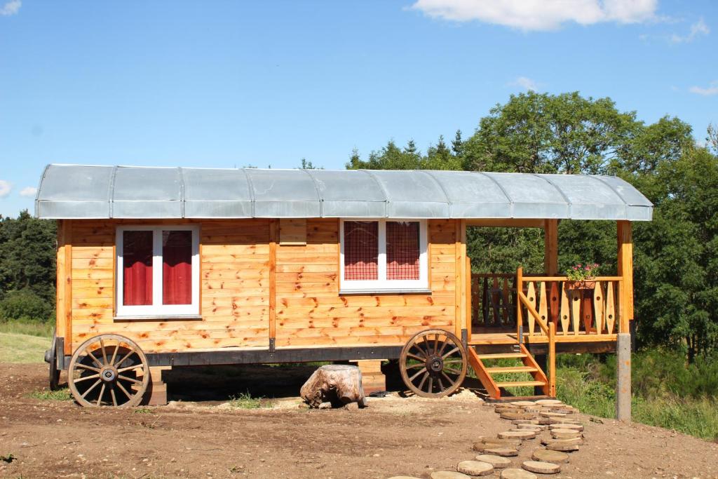 une maison en bois avec un toit sur un wagon en bois dans l'établissement roulotte impériale perchée-, à Sembadel