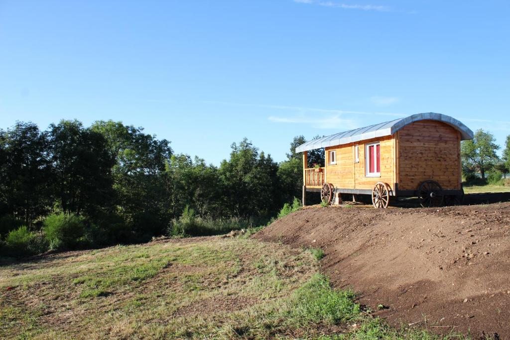 a tiny house sitting on top of a dirt hill at roulotte impériale perchée- in Sembadel