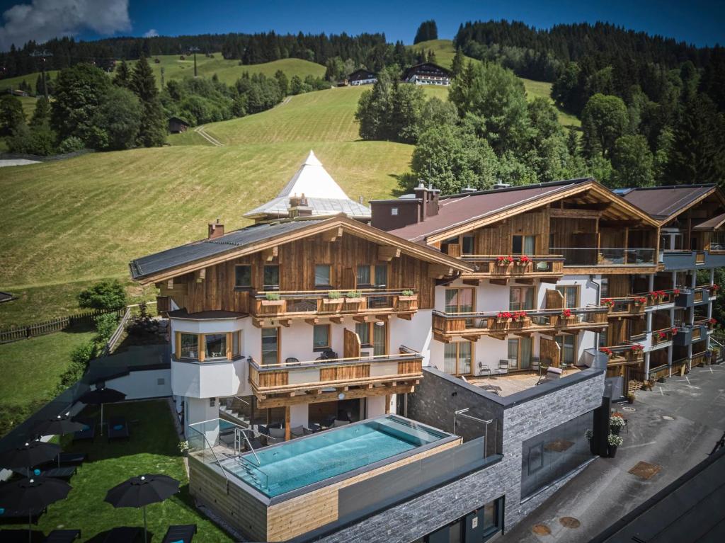 an aerial view of a house with a swimming pool at Hotel Astrid in Saalbach Hinterglemm