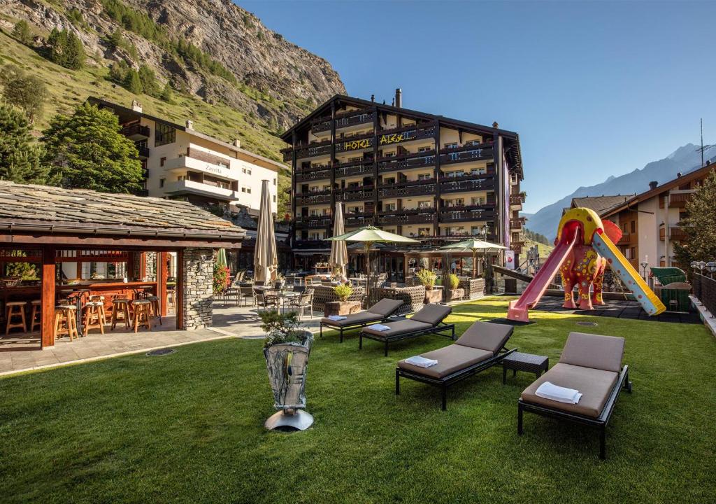 a playground with chairs and a slide on the grass at Resort Hotel Alex Zermatt in Zermatt