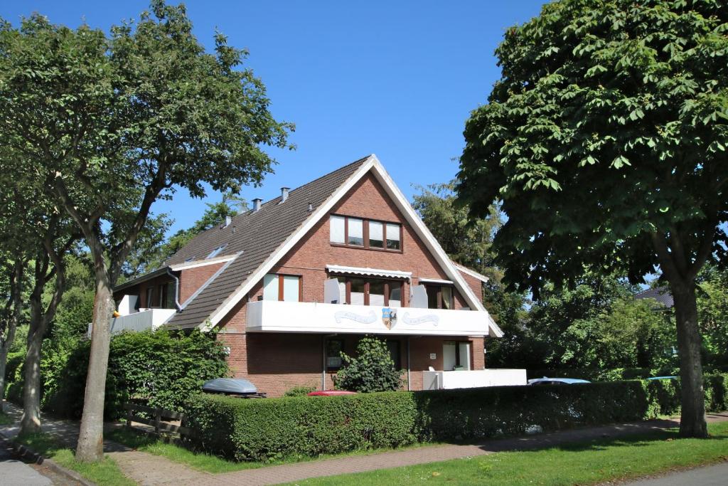 une maison brune avec un toit noir et des arbres dans l'établissement Badestra_e 80_ Whg_ 8_ Goting Hus, à Wyk auf Föhr