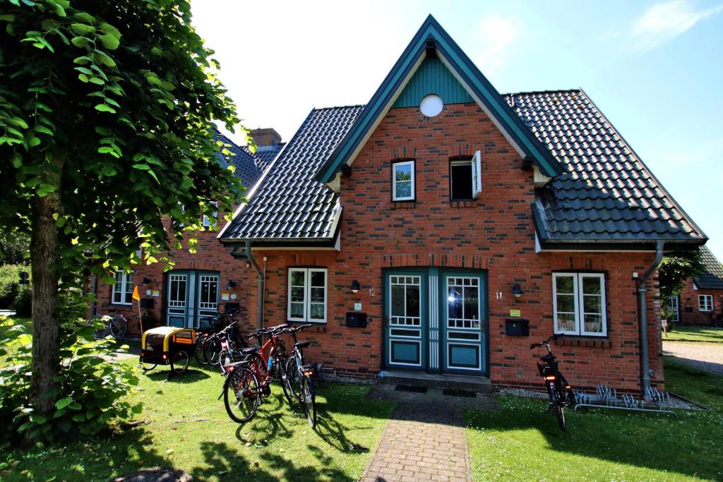 une maison en briques avec des vélos garés devant elle dans l'établissement Strandstra_e 8_ Whg_ 12_ Green Eil, à Wyk auf Föhr