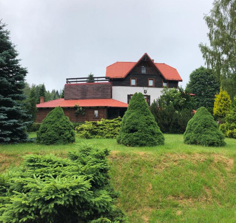 a house with a bunch of trees in front of it at Złoty Kłos in Szklarska Poręba