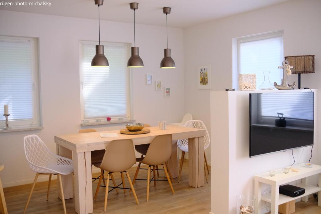 a kitchen with a table and chairs and a television at Ferienhaus Happytime in Binz