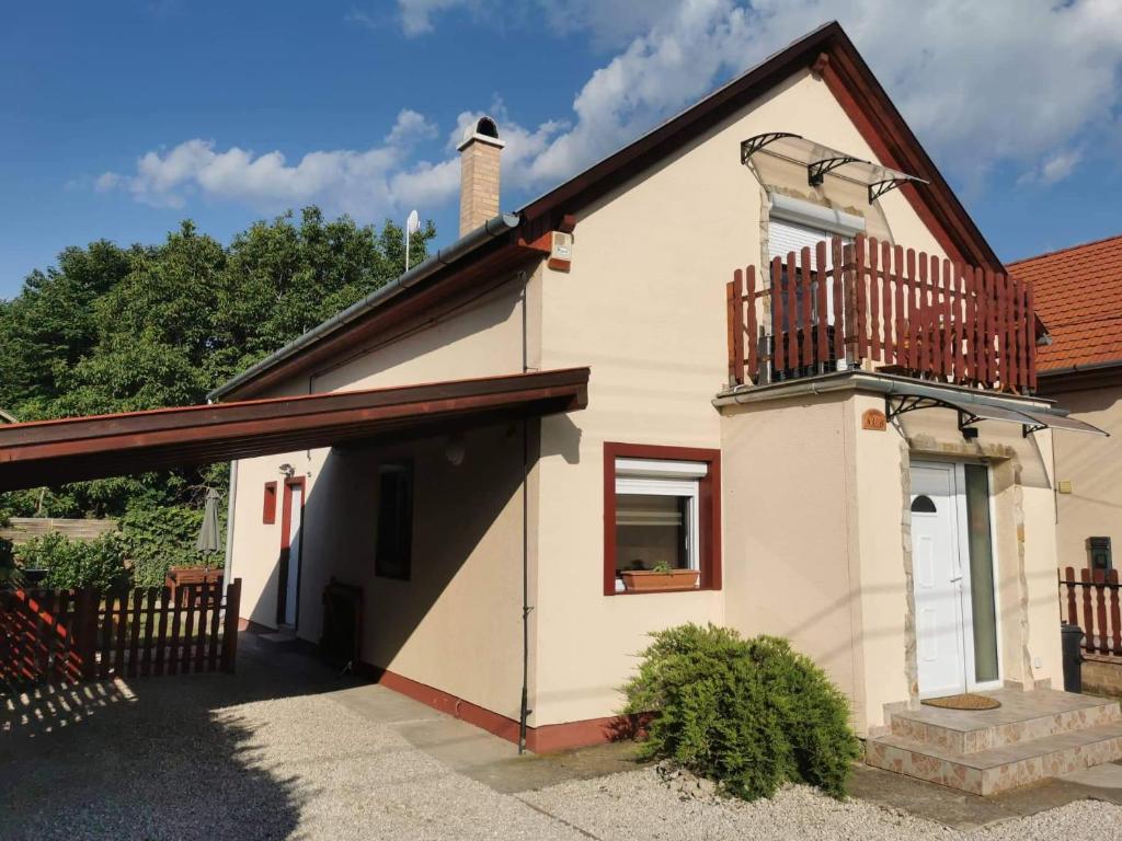 a small house with a balcony on top of it at Garden Vendégház Velence in Velence