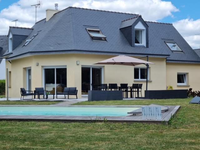 una casa con piscina frente a ella en Magnifique maison avec piscine à Beg Meil, en Fouesnant