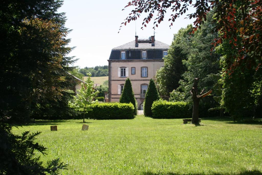 une grande maison au milieu d'une pelouse dans l'établissement Le Clos des Noyers, à Combronde