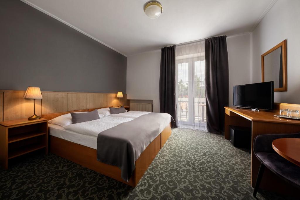 a hotel room with a bed and a television at Prague Hotel Carl Inn restaurant & Free Parking in Prague
