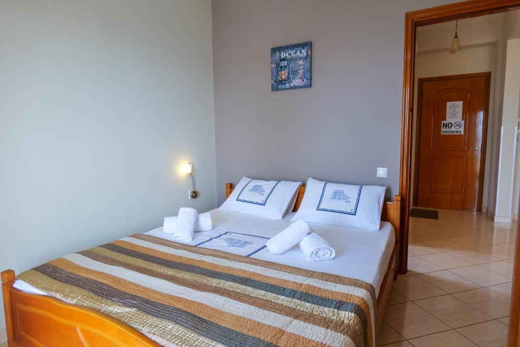 - une chambre avec un lit doté de draps et d'oreillers blancs dans l'établissement Elidon Apartments, à Saranda
