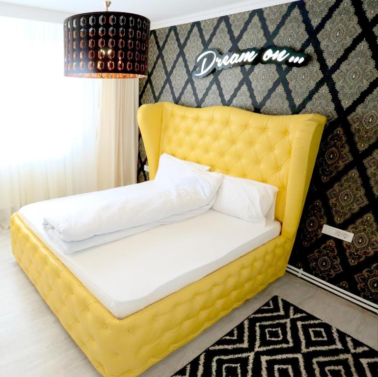 ガラツィにあるSOHO Apartment near CERONAVの壁付きの部屋の黄色いベッド