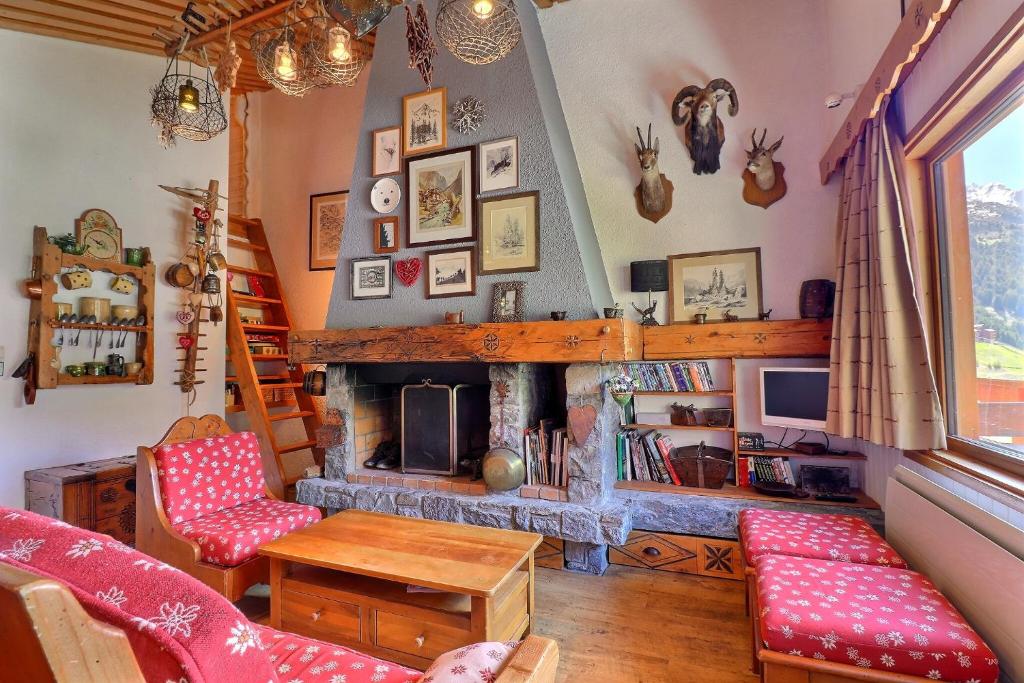 メリベルにあるRésidence Mont Vallonのリビングルーム(暖炉、赤い椅子付)