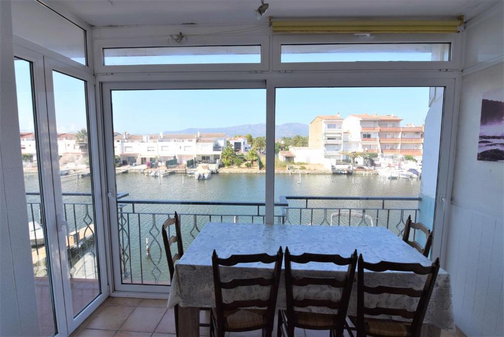 - une table sur un balcon avec vue sur l'eau dans l'établissement Apartamento con vistas canal ref 114, à Empuriabrava