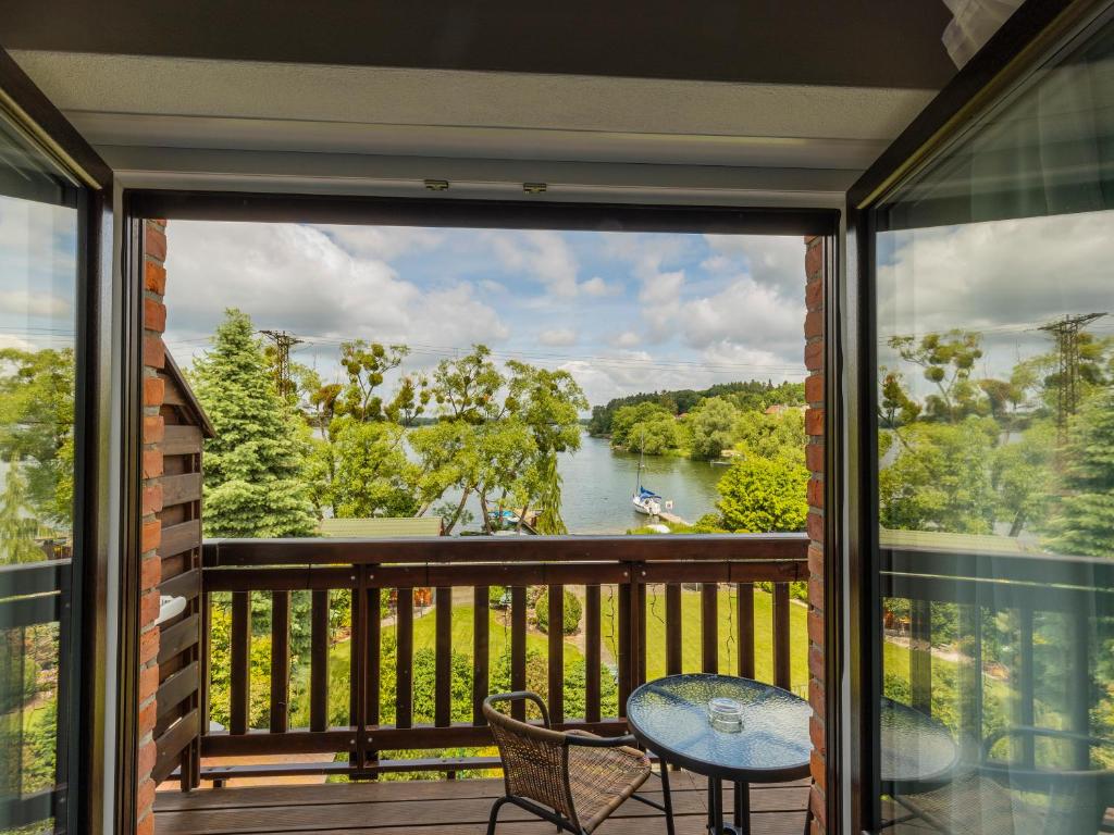 a balcony with a view of a river at Go Mazury in Mrągowo