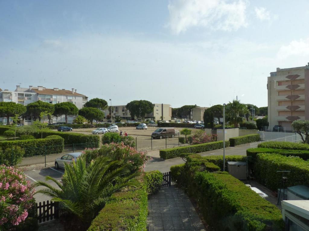 - une vue sur un parking avec des buissons et des voitures dans l'établissement Sol-y-Days Californie, Appartement confortable 4 personnes à 300m de la plage, au Grau-du-Roi