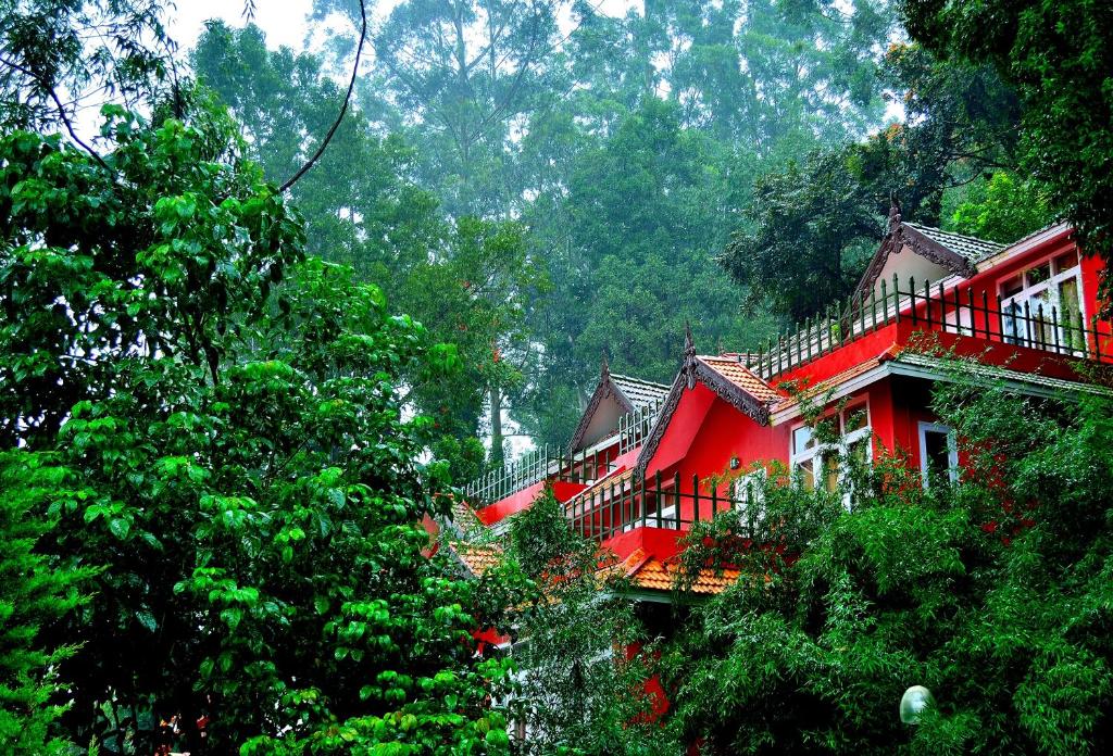 a red house in the middle of a forest at Tea Valley Resort, Munnar in Munnar