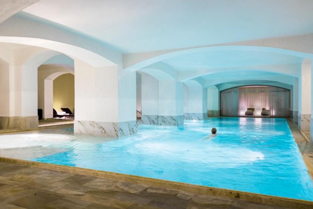 a swimming pool with a large tub and a pool table at NH Collection Carlo IV in Prague