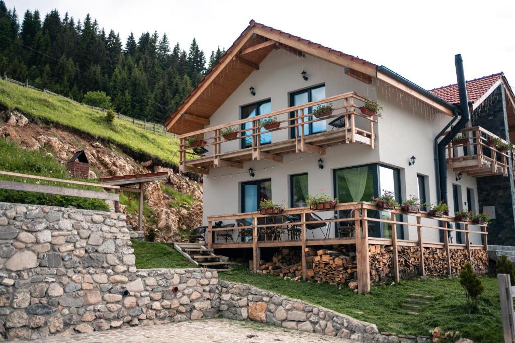 a house on a hill with a stone wall at Casa de Sub Munte Fundata in Fundata